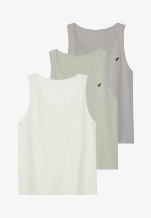 Trois débardeurs en crème clair, vert discret et gris. Tissu en coton doux avec un encolure dégagée et un petit logo noir sur chacun.