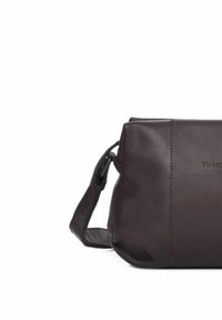 Bolso de hombro de cuero marrón con forma rectangular, textura suave, correa ajustable y un sutil logotipo estampado en el lateral.