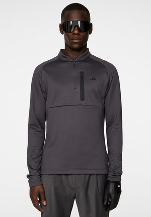 Pullover sportivo grigio scuro con chiusura a mezza zip, dotato di tasca sul petto e maniche lunghe. Inclusi occhiali da sole neri lucidi e guanti.
