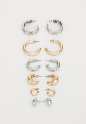 Ensemble de huit boucles d'oreilles en métal aux teintes argentées et dorées. Comprend différents styles de créoles, textures et fins, classés par taille.