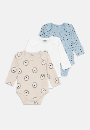 Tris ilgomis rankovėmis kūdikių bodysuitų: smėlinis su liūto piešiniu, baltas vientisas ir šviesiai mėlynas su juodais taškais. Visi pagaminti iš minkštos medvilnės.