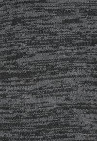 Mörkgrå och svart melerad stickad tyg med en texturerad, något fluffig ytmönster.
