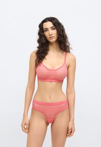 Ροζ δαντελένιο bralette με λεπτές τιράντες και ταιριαστό δαντελένιο στρινγκ. Μαλακή υφή, λαιμόκοψη σε σχήμα V, και λεπτά κυματιστά μοτίβα σε όλο το ύφασμα.