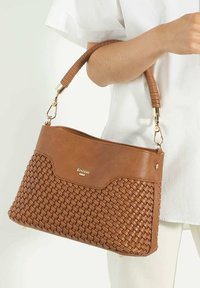Brown woven leather handbag with a smooth top section, braided handle, gold-tone hardware, and brand logo on the front.