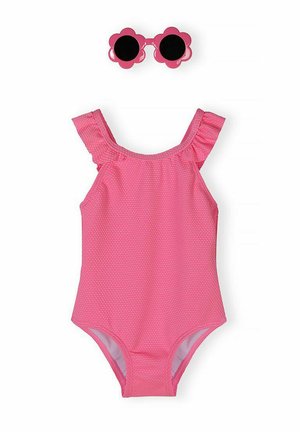 Różowy teksturowany jednoczęściowy kostium kąpielowy z falbankami na ramionach oraz różowe okulary przeciwsłoneczne w kształcie kwiatów z czarnymi soczewkami powyżej.