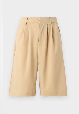 Beige knielange, maßgeschneiderte Shorts mit Gürtelschlaufen, vorderen Falten und verdecktem Frontverschluss auf einfarbigem hellem Hintergrund.