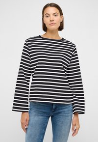 Pika varrukaga särk, millel on musta-valge horisontaaltriibud, valmistatud pehmest kangast, ümar kaelus ja lõdvestunud istuvus.