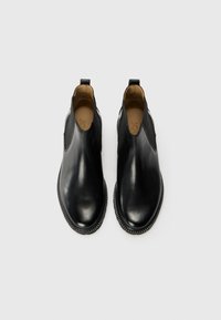 Black leather ankle boots with elastic side panels, rounded toe, and contrasting textured stitching along the sole.