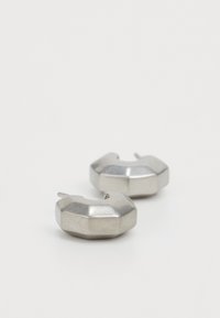Metalliske sølvøreringer med en geometrisk design, som har en oktagonal form og en struktureret overflade. Stikfastgørelser inkluderet.