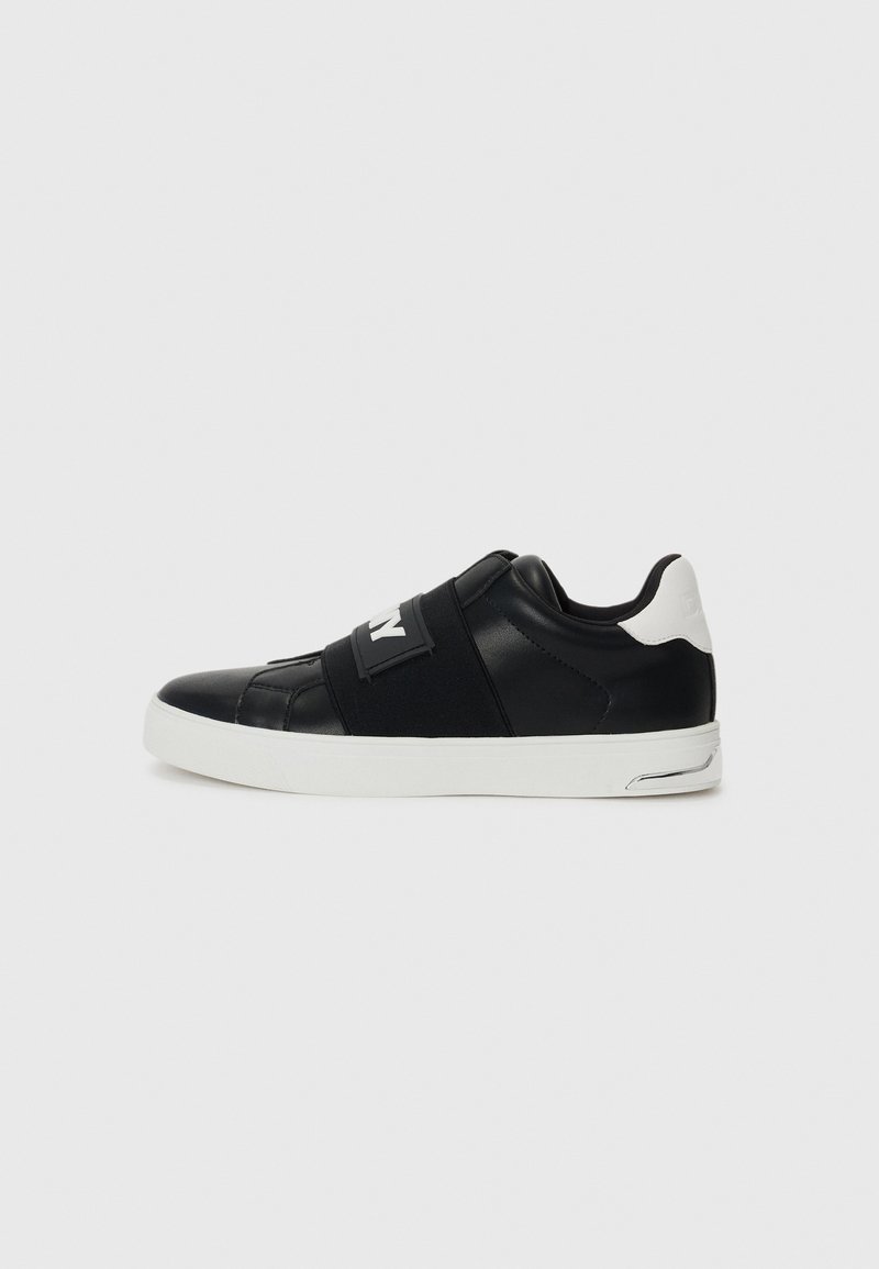 Baskets de sport noires avec une tige en cuir lisse, des sangles élastiques et une semelle en caoutchouc blanc. Comprend des détails renforcés au niveau des orteils et du talon.