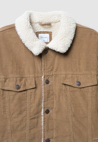 Giacca in velluto a coste color cammello con colletto in sherpa bianco, chiusura frontale con bottoni e tasche sul petto con pattina e bottoni a pressione.