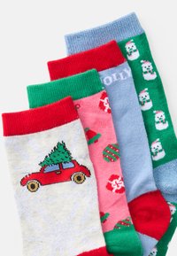 Cuatro pares de calcetines festivos: con patrones rojos y verdes, de color azul claro con la palabra "HOLLY", un coche con un árbol, y un diseño de adornos entrelazados.