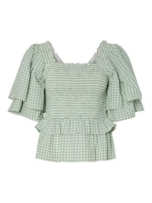 Blusa a quadri verde e bianca con maniche corte e arricciate, corpino smockato e orlo peplum svasato. Accentuata da un collo a onde.