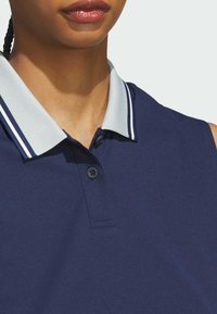 Navy blue sleeveless polo shirt featuring a textured gray collar with white accents and two black buttons at the neckline.