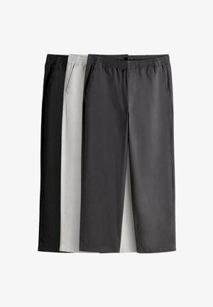 Trei perechi de pantaloni casual cu talie elastică în negru, gri deschis și gri închis, așezate unul lângă altul pe un fundal alb.