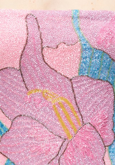 Približen pogled rožnatega cveta z rumenimi prašniki in modro-zelenimi listi, ustvarjenega iz majhnih valjastih perlic v mozaik vzorcu.