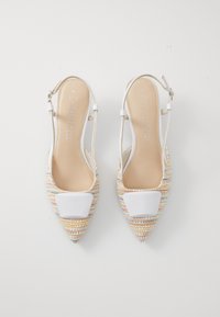 Zapatos tipo slingback con punta afilada, texturización tejida multicolor y acentos blancos. Correa ajustable, forro interior suave y tacón plano.