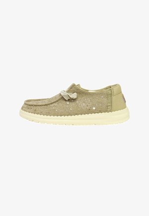 Scarpa casual marrone chiaro slip-on con tessuto strutturato, paillettes decorative, lacci annodati sulla parte superiore e suola bianca.