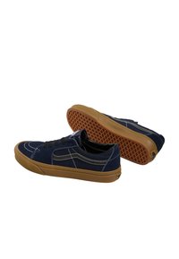 Baskets en daim bleu marine avec accents noirs, surpiqûres blanches, lacets noirs et semelle en caoutchouc gomme présentant un motif de grip texturé.