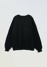 Czarny sweter z luźnym krojem, rękawami raglanowymi oraz ściągaczami przy mankietach i dole. Wykonany z miękkiego materiału, o gładkiej fakturze.
