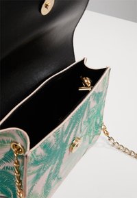 Floral-patterned handbag in green and pink synthetic material, featuring a black interior, gold hardware, and a chain strap.