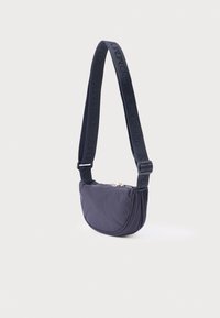 Námornícka nylonová taška na rameno s oblým, mäkkým tvarom. Má textúrovaný popruh s vyrazeným logom a kovové zipsové zatváranie.