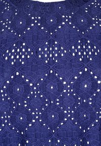 Jūras zila mežģīņu audums ar sarežģītu dimanta rakstu un izgriezumiem, veidojot teksturētu, atvērtu dizainu.