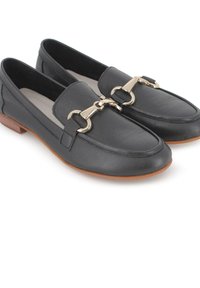 Mocasines de cuero negro con un tacón bajo, que presentan un detalle metálico en tono dorado a lo largo del empeine y una textura suave en la parte superior.
