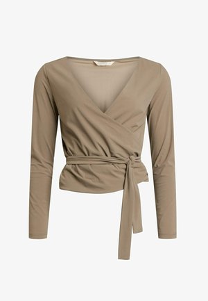 Haut beige à manches longues enroulé avec un décolleté en V profond, ceinture à la taille et texture froncée. Fabriqué en tissu lisse avec un léger éclat.