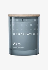 Blauer Glas-Teelichthalter mit Holzdeckel, mit weißen geprägten Symbolen und dem Text "SKANDINAVISK OY Island Einsamkeit" an der Basis.