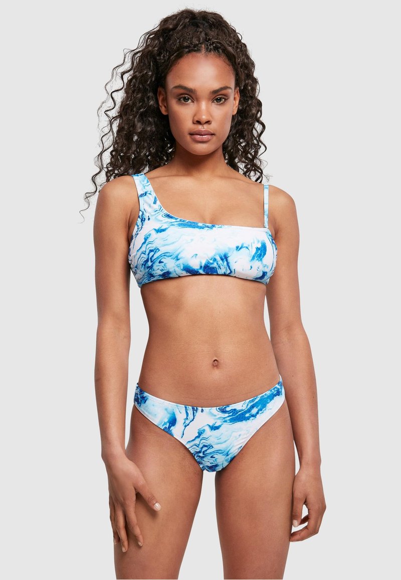 Bikini set u plavo-bijelom mramornom uzorku; gornji dio s jednim naramenicom, donji dio je s niskim strukom i umjerenim pokrićem.
