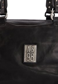 Zwarte leren handtas met metalen merkplaat met de tekst "A.S. 98" en leren hengsels bevestigd met metalen ringen en klinknagels.