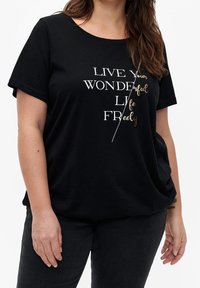 Sort bomulds t-shirt med korte ærmer og rund halsudskæring, prydet med hvid og guld tekst der står "LEV dit VIDUNDERLIGE LIV FRIT."