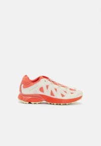 Lightweight athletic shoes featuring a breathable mesh upper in white and coral, with a textured sole and distinctive cut-out design.