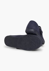 Zapatillas de tela en color marino con un upper texturizado, forma redondeada y suela de goma negra flexible con patrones florales y detalles en relieve.