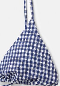 Haut de bikini triangulaire à carreaux bleus et blancs avec un tissu texturé, des bretelles fines réglables et un détail froncé en bas.