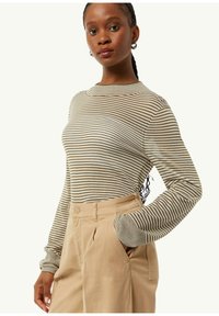 Langsleeve gestreepte top in aardetinten, met een ronde hals en aansluitende mouwen, gecombineerd met beige op maat gemaakte broeken met een zijzak.