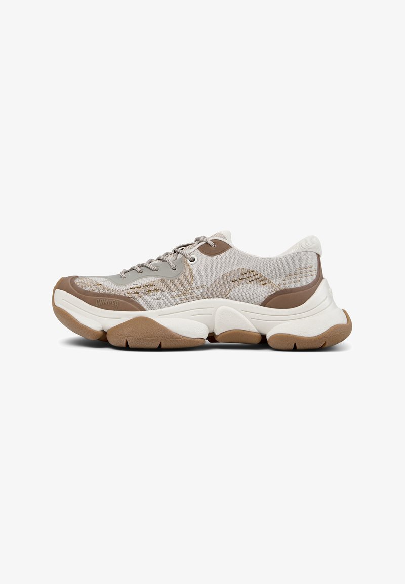 Jasnoszare siateczkowe sneakersy z brązowymi akcentami, teksturowane podeszwy oraz zaokrąglony, masywny kształt. Posiadają zaokrąglony czubek i sznurowane zapięcie.