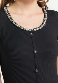 Robes noires à manches courtes côtelées avec décolleté en U, ornées d'une bordure perlée et de boutons dorés sur le devant.