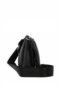 Borsa a spalla nera in pelle con finitura testurizzata, dotata di una cerniera in argento e una tracolla nera regolabile con logo imprintato.