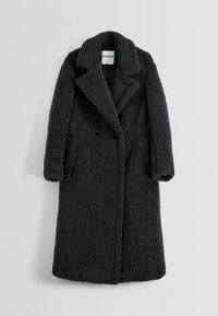 Abrigo negro extragrande hecho de material de forro polar texturizado. Cuenta con cuello con muesca, cierre frontal con botones y bolsillos laterales.