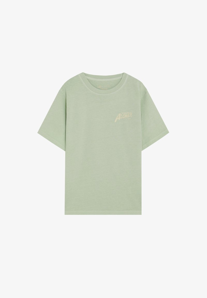 T-shirt vert clair à manches courtes et col rond, avec un petit texte beige « California Aloha » sur le haut gauche de la poitrine.