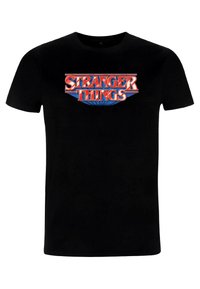 Sort bomuld t-shirt med et livligt, retro-inspireret "STRANGER THINGS" logo i rødt og blåt. Kortærmet og med klassisk rund hals.