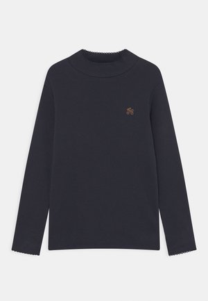 Długi rękaw, granatowy prążkowany top z dekoltem w kształcie falbanki, z małym haftowanym logo w złotym kolorze na lewej piersi.