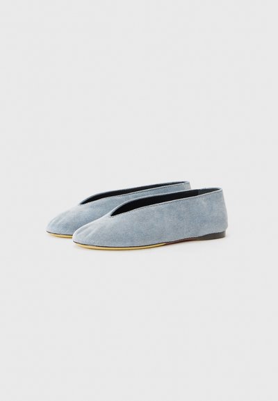 Lysblå stof balletflade med v-skåret front, flad sort sål og glat tekstur. Enkel design, ingen synlige mønstre eller detaljer.