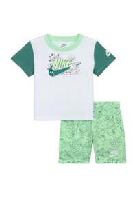 Maglietta bianca Nike a maniche corte con dettagli verdi e grafiche; pantaloni corti verde menta abbinati con motivi di scarabocchi giocosi e logo.