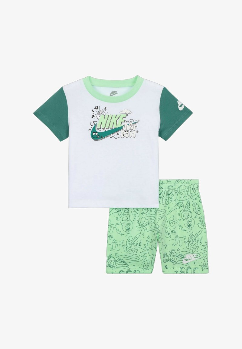 Maglietta bianca Nike a maniche corte con dettagli verdi e grafiche; pantaloni corti verde menta abbinati con motivi di scarabocchi giocosi e logo.