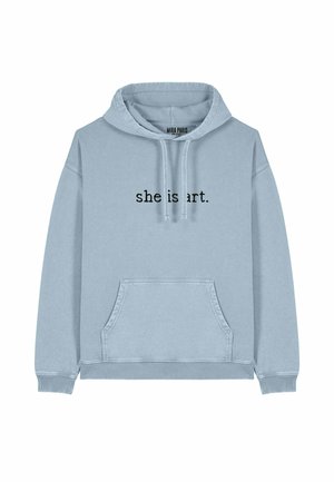 Lichtblauwe hoodie van zachte stof, met een voorzak en trekkoorden. De tekst "she is art." is in zwart op de voorkant gedrukt.