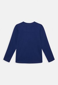 Námořnická košile s dlouhým rukávem vyrobená z měkké bavlny. Má kulatý výstřih a rovný střih. Hladká textura bez viditelných vzorů nebo akcentů.