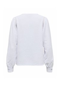 Blouse blanche texturée à manches longues avec manches bouffantes et détails en dentelle le long des coutures des épaules, vue de dos.